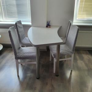 a white table with four chairs in a room at Apartment Beauty in Vilnius