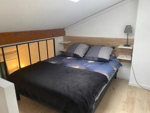 sypialnia z dużym łóżkiem z drewnianym zagłówkiem w obiekcie Le petit Atelier w mieście Eyguières +7 zdjęć