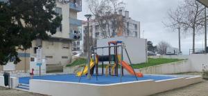 a playground with a slide on a blue at Charming T1 apartment in Seixal in Aldeia de Paio Pires