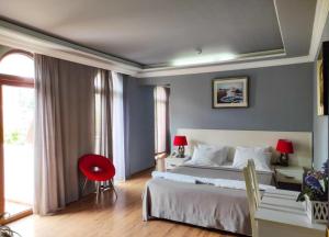 Un dormitorio con una cama grande y una silla roja. en Aparthotel Old City, en Batumi