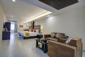 um quarto de hotel com uma cama e um sofá em The Bindal Hotel em Jamshedpur