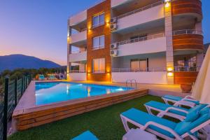 a villa with a swimming pool and lounge chairs at Azize 6 in Fethiye