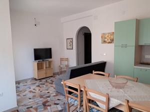 a living room with a table and a couch at Casa vacanze Serra in Bari Sardo