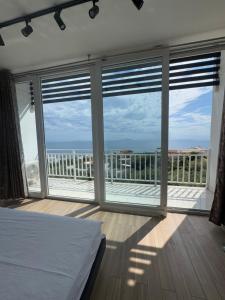 a bedroom with a bed and views of the ocean at Privat Pool Garden Villa in Gjilek +23 photos