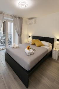 a bedroom with a large bed with towels and flowers on it at NAPOLI VIBES Rooms in Naples