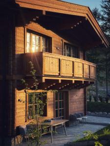 a wooden house with a balcony and a table at Sissi green Chalets in Seefeld in Tirol