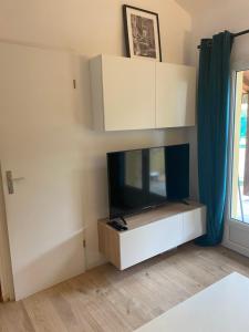 salon z telewizorem z płaskim ekranem na ścianie w obiekcie Le petit Atelier w mieście Eyguières