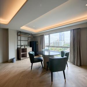 a dining room with a table and chairs and a large window at The Path Siam in Bangkok