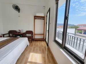 ein Schlafzimmer mit Bett und großen Fenstern in der Unterkunft Homestay Thành Thắng in Ninh Bình