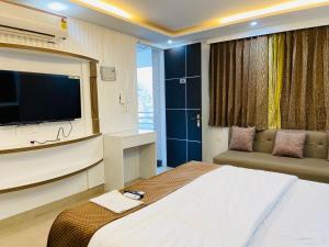 a bedroom with a large bed with a flat screen tv at The Starfish Studio , Mussoorie road in Dehradun