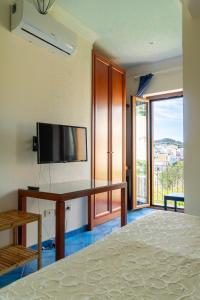 a bedroom with a desk with a tv and a bed at Villa Acacia in Ponza