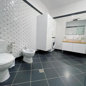 a bathroom with two toilets and a sink at ODORE DI MARE APARTMENTs in Sarandë +100 photos