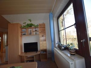 ein Wohnzimmer mit Fernseher und Fenster in der Unterkunft Snug Apartment in Kröpelin Germany in Klein Nienhagen