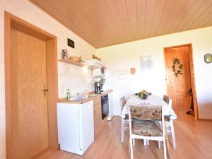 eine kleine Küche mit einem Tisch, einem Tisch und Stühlen in der Unterkunft Snug Apartment in Kröpelin Germany in Klein Nienhagen