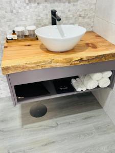 a bathroom sink with a white bowl on a wooden counter at Bella Casa Bed and Breakfast in Ponta Delgada +73 photos