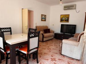 a living room with a table and a couch and a television at Haxhialiu Villa in Berat +10 photos