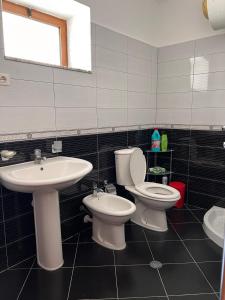 a bathroom with two toilets and a sink at Haxhialiu Villa in Berat