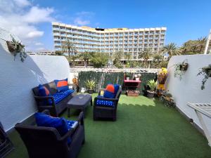 un patio con sedie e tavoli e un edificio di Apartamento Tropicana a Denia