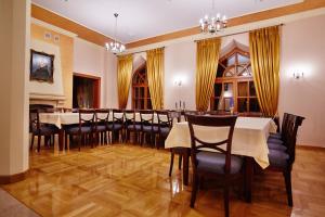 a dining room with a long table and chairs at Centrum Obsługi Turysty Kordegarda in Raczki
