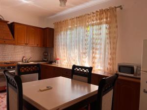 a kitchen with a table and chairs and a window at Haxhialiu Villa in Berat