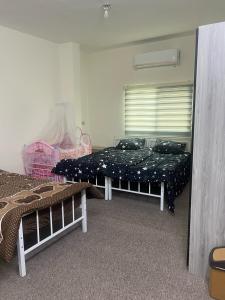 a bedroom with two beds and a window at Altamem apartment in Um Qeis
