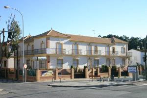 a large white building on the corner of a street at Apartamentos Turisticos Paraíso Andaluz in Isla Cristina