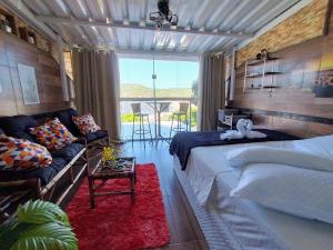 una camera da letto con un letto, un divano e un tavolo di PraiAna Loft Arraial do Cabo ad Arraial do Cabo