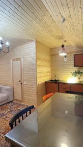 a living room with a table and a kitchen at Экохаус Бурабай 1 in Borovoye