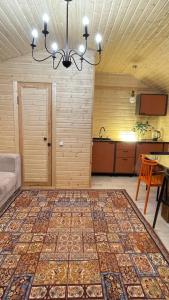 a living room with a chandelier and a large rug at Экохаус Бурабай 1 in Borovoye +2 photos