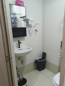 a white bathroom with a sink and a mirror at Doroin Krib Staycation in Manila