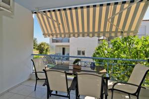 a patio with a table and chairs on a balcony at The Sea House 3 in Yerakiní