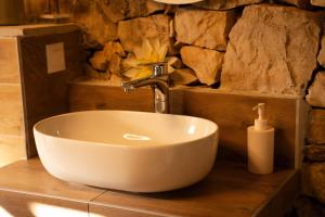 a white sink in a bathroom with a stone wall at Beach Garden Brač in Mirce +43 photos