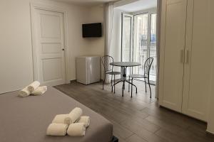 a room with a bed and a table and chairs at NAPOLI VIBES Rooms in Naples +32 photos