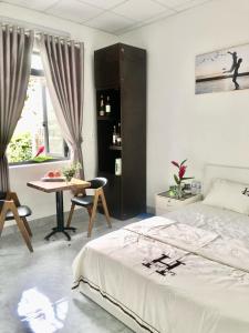Buôn ÐũngHomestay Buôn Mê 4的一间卧室，配有一张床、一张桌子和一张书桌
