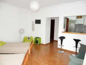 Sala de estar con 2 camas y mesa en Apartamentos Turísticos Pérola da Rocha II, en Portimão
