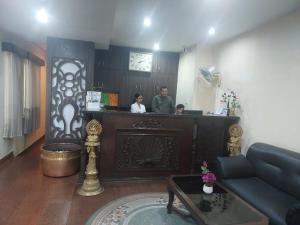two people standing at a bar in a living room at Landmark Narayani in Chitwan