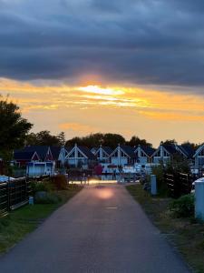 a road leading to a row of houses at sunset at Hyggely Marie Sophie in Wandlitz