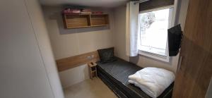 a small room with a bed and a window at Mobilhome 6-8 pers - 3 ch - 1 sdb - Parc Aquatique in Vias