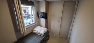 a small room with a window and a television at Mobilhome 6-8 pers - 3 ch - 1 sdb - Parc Aquatique in Vias