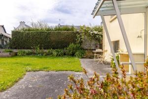 un jardín con un seto y una casa en Le St Laurent, en Plérin