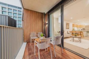 balcón con mesa y sillas y sala de estar. en Convenient City Pad - 2BR Laundry Sleeps 5, en Christchurch