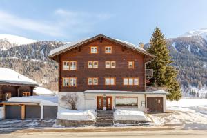 a large wooden house in the snow with mountains at Sunny Mountain in Reckingen - Gluringen