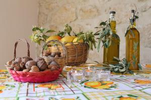 a table with baskets of fruit and bottles of wine at Tenuta Lanza Il Mulino in Acquaviva Platani