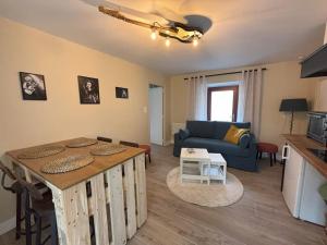 a living room with a table and a blue couch at Aux 12 instants, Imagine in Lédergues +62 photos
