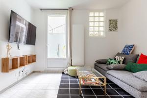 ein Wohnzimmer mit Couch und Tisch in der Unterkunft T3 de standing - Porte de Paris - Stade de France in Saint-Denis