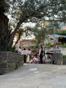 a group of people are standing under a tree at Hramišče, Botega in Šmarje
