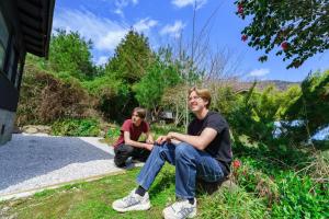 two people sitting on the grass near a house at SAMURAI Base in Hakone