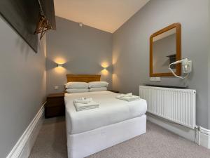 a bedroom with a white bed and a mirror at Preston Park Hotel in Brighton & Hove +33 photos