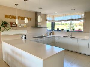 a kitchen with white cabinets and a counter top at Villa de Lujo en Campo de Golf - Costa Brava in Peralada