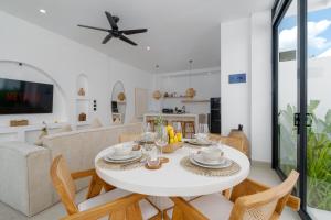 a dining room and living room with a white table and chairs at Casa Agapi in Tumbak Bayuh